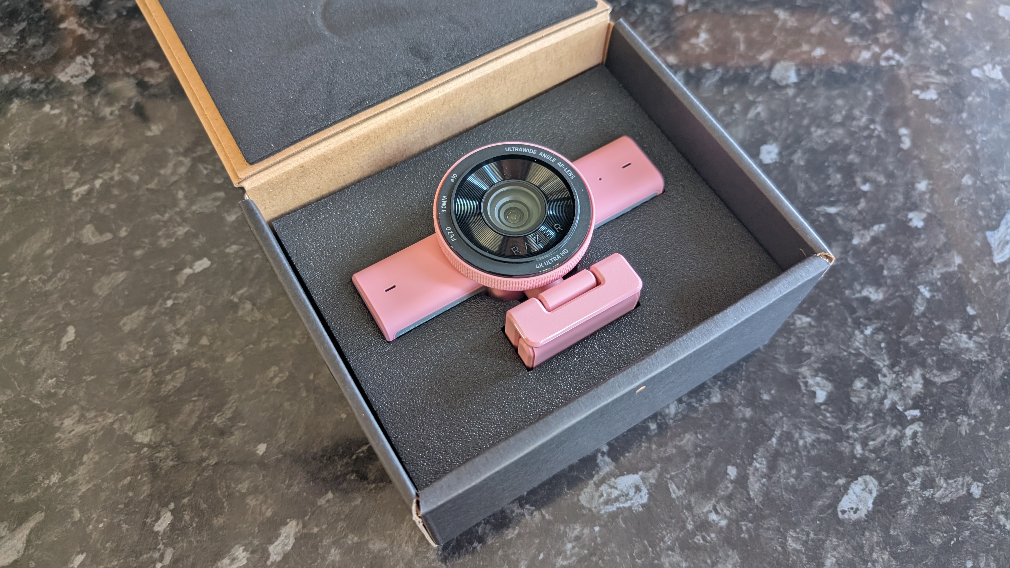 The Razer Kiyo V2 webcam pictured on a dark marble worksurface.