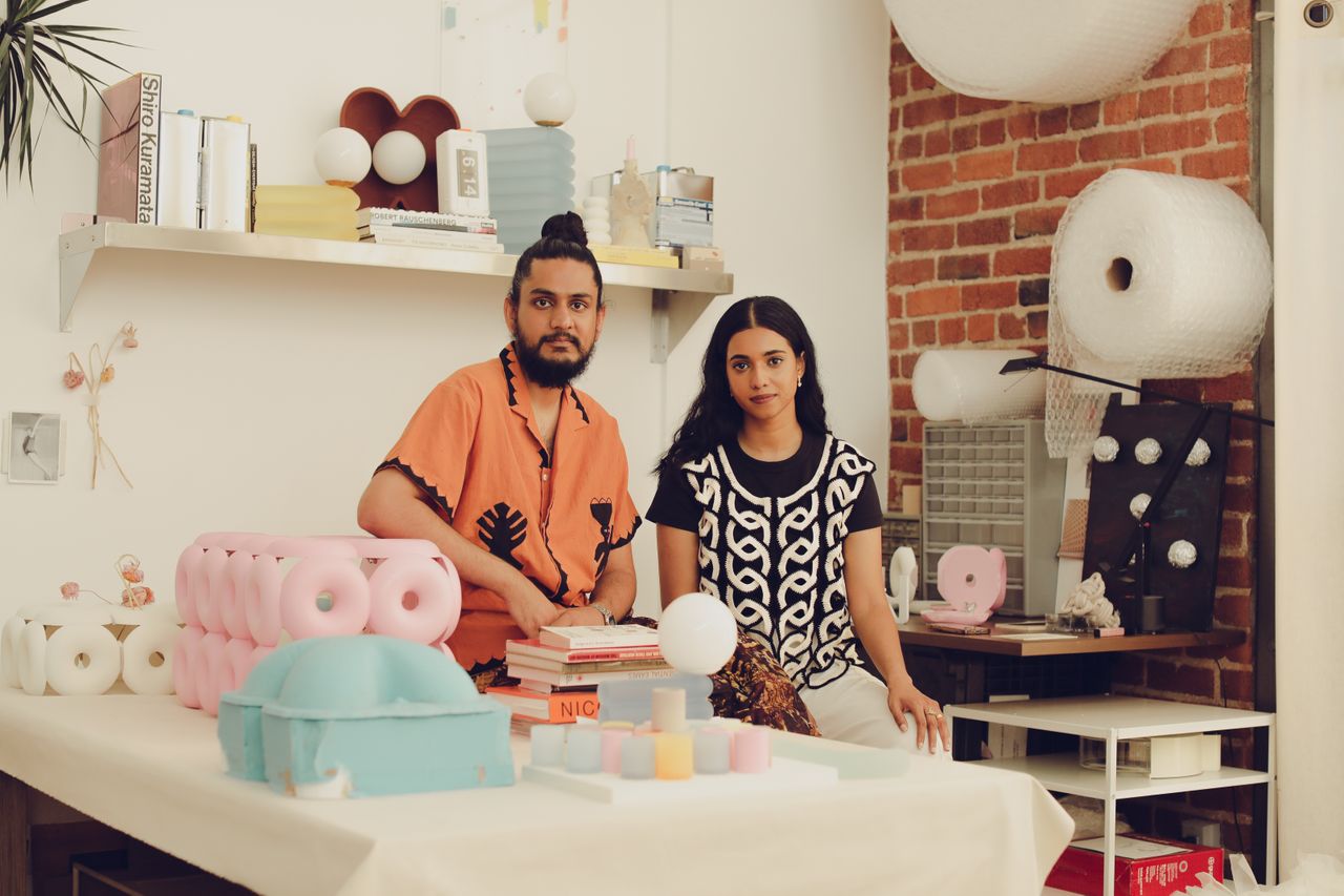 Two young artisans at work in their creations-filled, naturally lit studio.