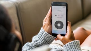 Woman lying down listening to streamed music from her phone