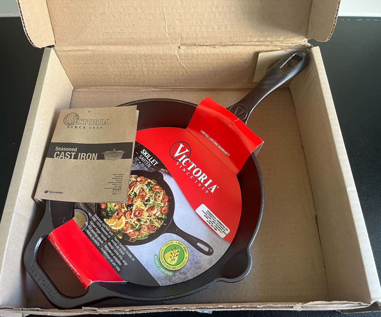 A small black cast-iron skillet inside a cardboard box
