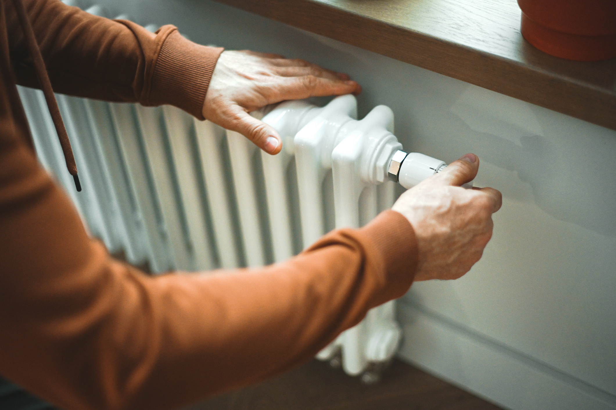 Person adjusting the settings on their radiator