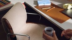 A home office with a desk chair that has a seat warmer on top of it