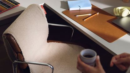 A home office with a desk chair that has a seat warmer on top of it 