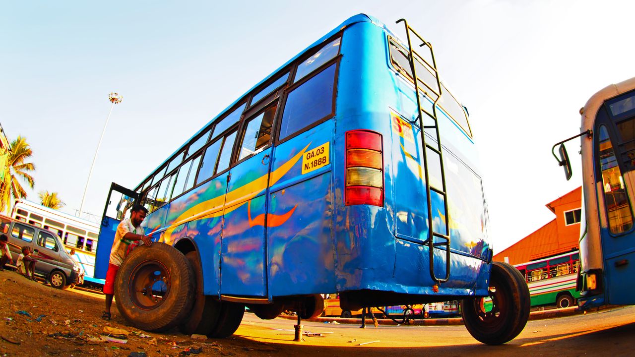 Fisheye lens photo of a man changing a tyre on a bus in India