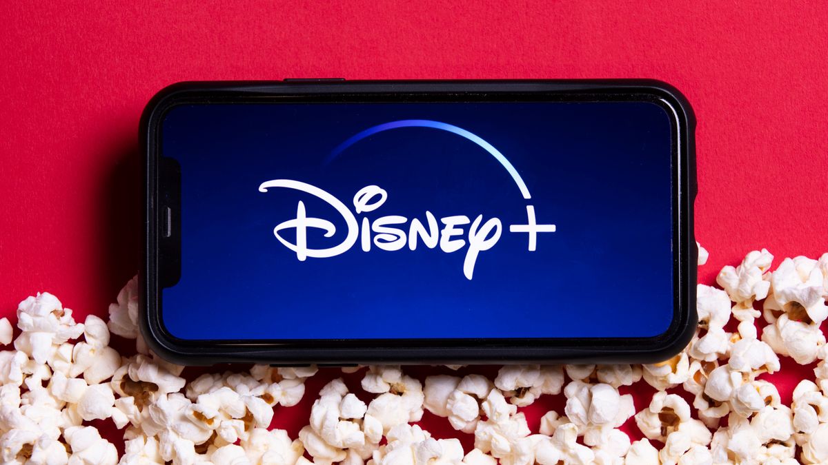 The Disney Plus logo on a phone surrounded by popcorn