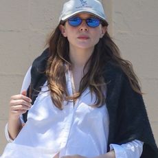 Elizabeth Olsen leaving lunch at All Time Restaurant in Los Angeles wearing a white button-down shirt, eyelet-trim pants, and black loafers.