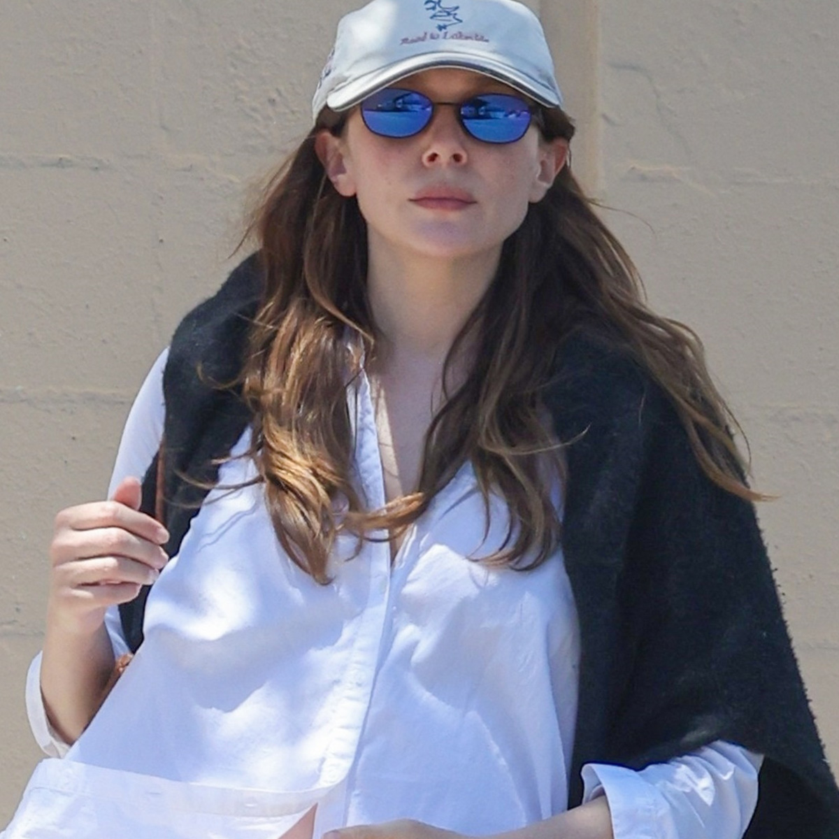 Elizabeth Olsen leaving lunch at All Time Restaurant in Los Angeles wearing a white button-down shirt, eyelet-trim pants, and black loafers.