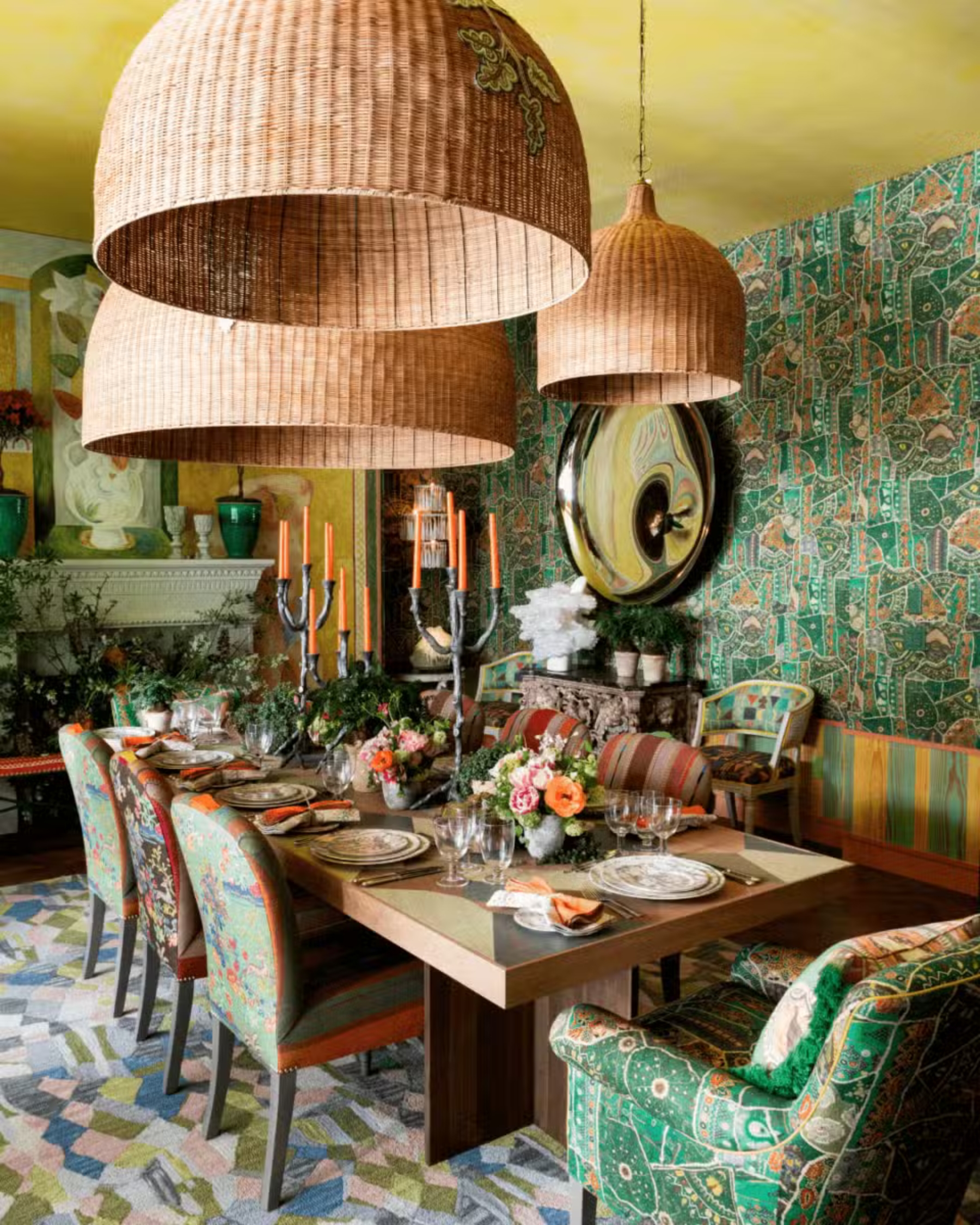 a dining room with large basket lights, and lots of green patterned textiles