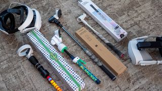 A handful of different Meta Quest golf club accessories alongside a Meta Quest 3 and Quest 3S headset