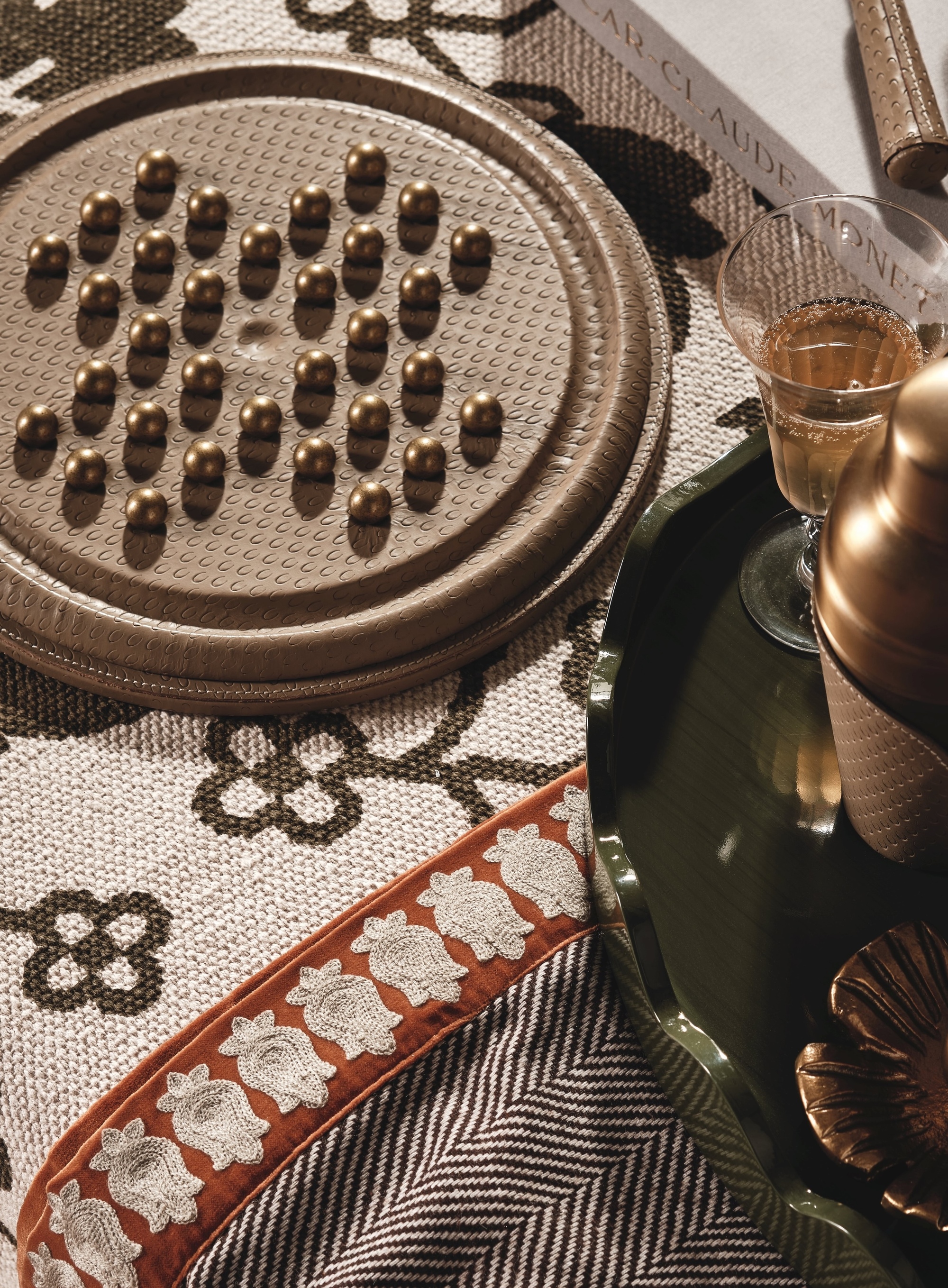 close up of patterned blanket, with board game, and bar tray with glass of champagne