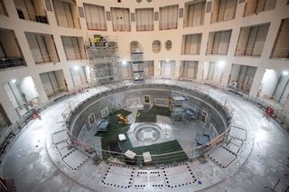 Technicians work on the bioshield inside the Tokamak Building with the base of the cryostat at its base during the launch of the assembly stage of nuclear fusion machine "Tokamak" of the International Thermonuclear Experimental Reactor (ITER) in Saint-Paul-les-Durance, southeastern France, on July 28, 2020.