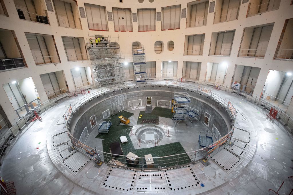 Technicians work on the bioshield inside the Tokamak Building with the base of the cryostat at its base during the launch of the assembly stage of nuclear fusion machine 