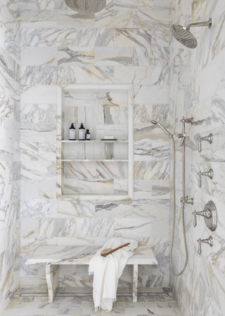 full marble clad shower room with a marble bench and marble storage