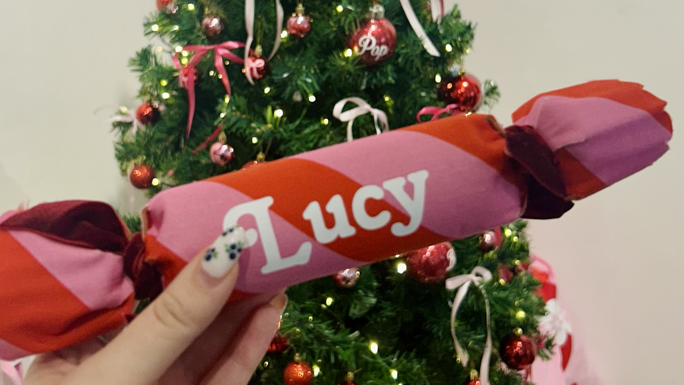 Hand holding christmas bon bon with name on it