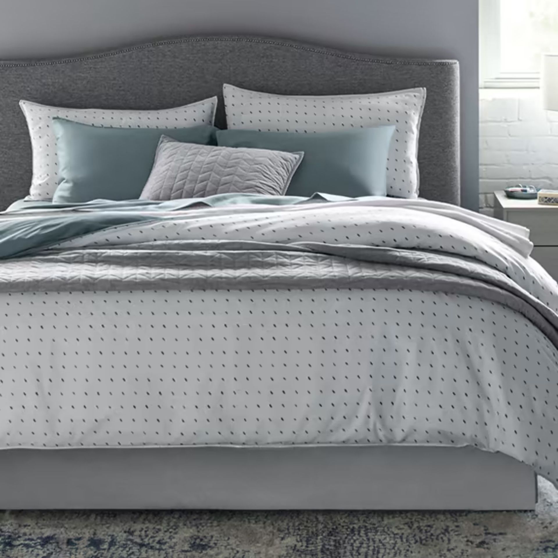 Smart Skirt on a bed against gray walls.