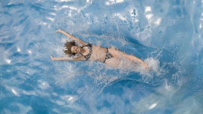 Woman wearing bikini, smiling and swimming