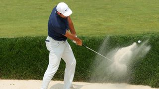 Scottie Scheffler hitting out of a bunker at Oak Hill ahead of the 2023 PGA Championship