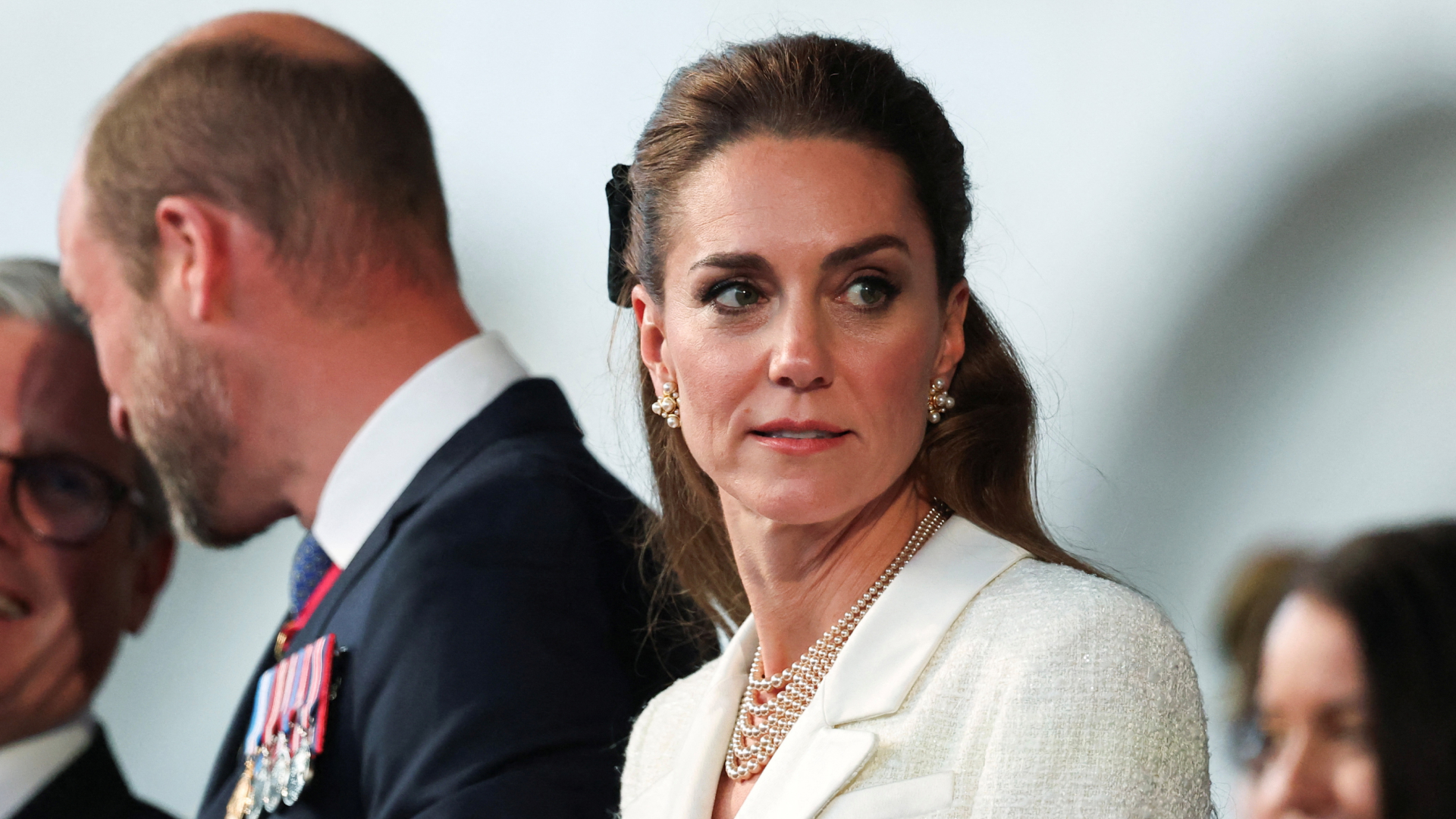 Kate Middleton wearing a white tweed blazer dress and pearl necklace at a VE Day anniversary concert