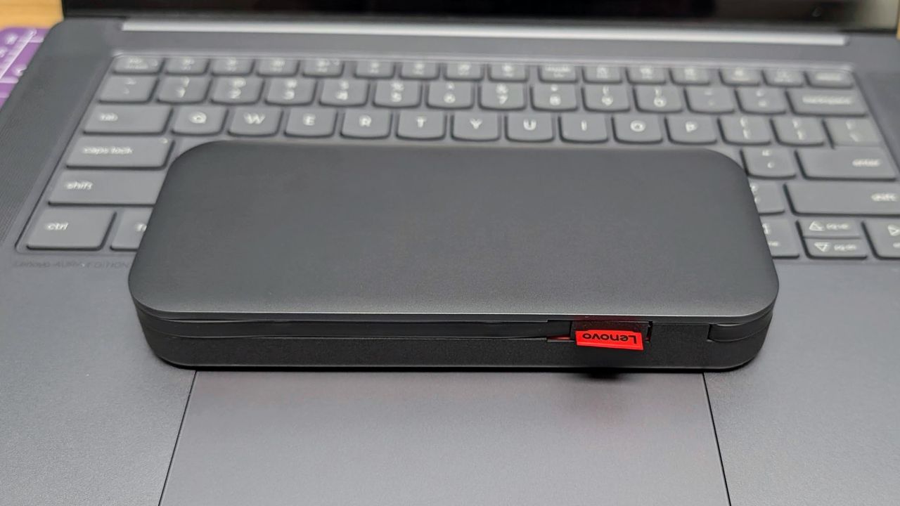 Lenovo Go USB-C laptop power bank sitting on a Yoga Slim 7i laptop to show the size