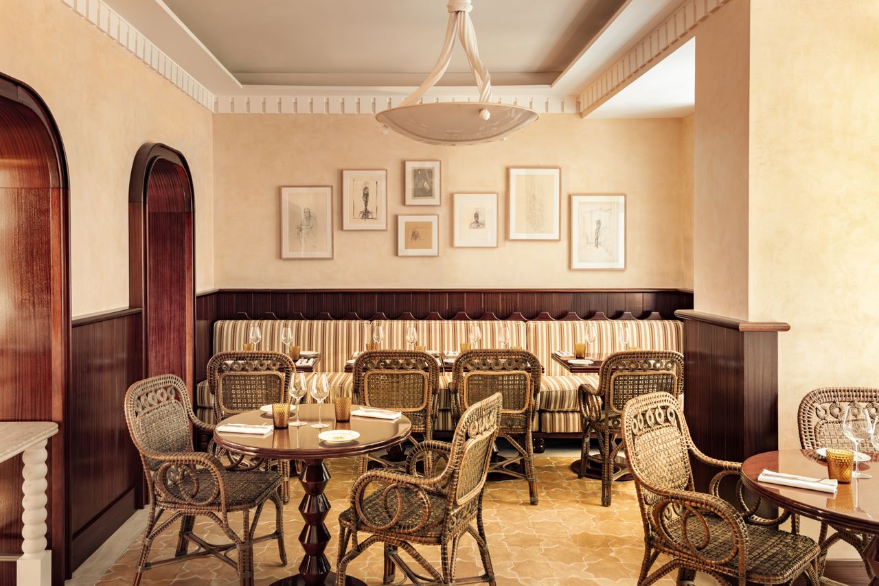 A maximalist hotel in Rome features vibrantly decorated, layered interiors, including plush upholstery, rattan accents, sculptural lighting, and artefacts.