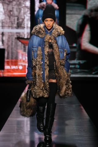 Model wearing denim jacket, black hat and boots at dolce & Gabbana f/w 25 show.