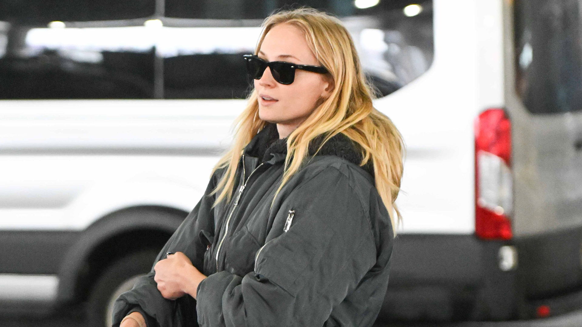 Sophie Turner is spotted at JFK airport in a groutfit, including a bomber jacket and Adidas Samba sneakers.