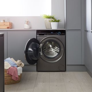 Dark grey washing machine with door open in laundry room