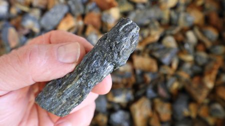 A person holding a piece of antimony