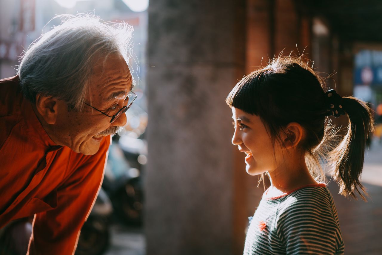 A delighted grandfather talks to his granddaugher.