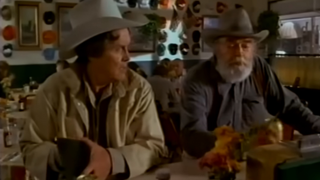 Two men sitting at a lunch counter, wearing cowboy hats