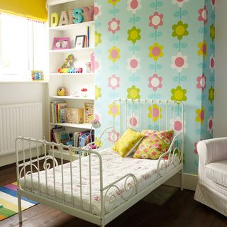 children's bedroom with wallpaper on wall and metal bed