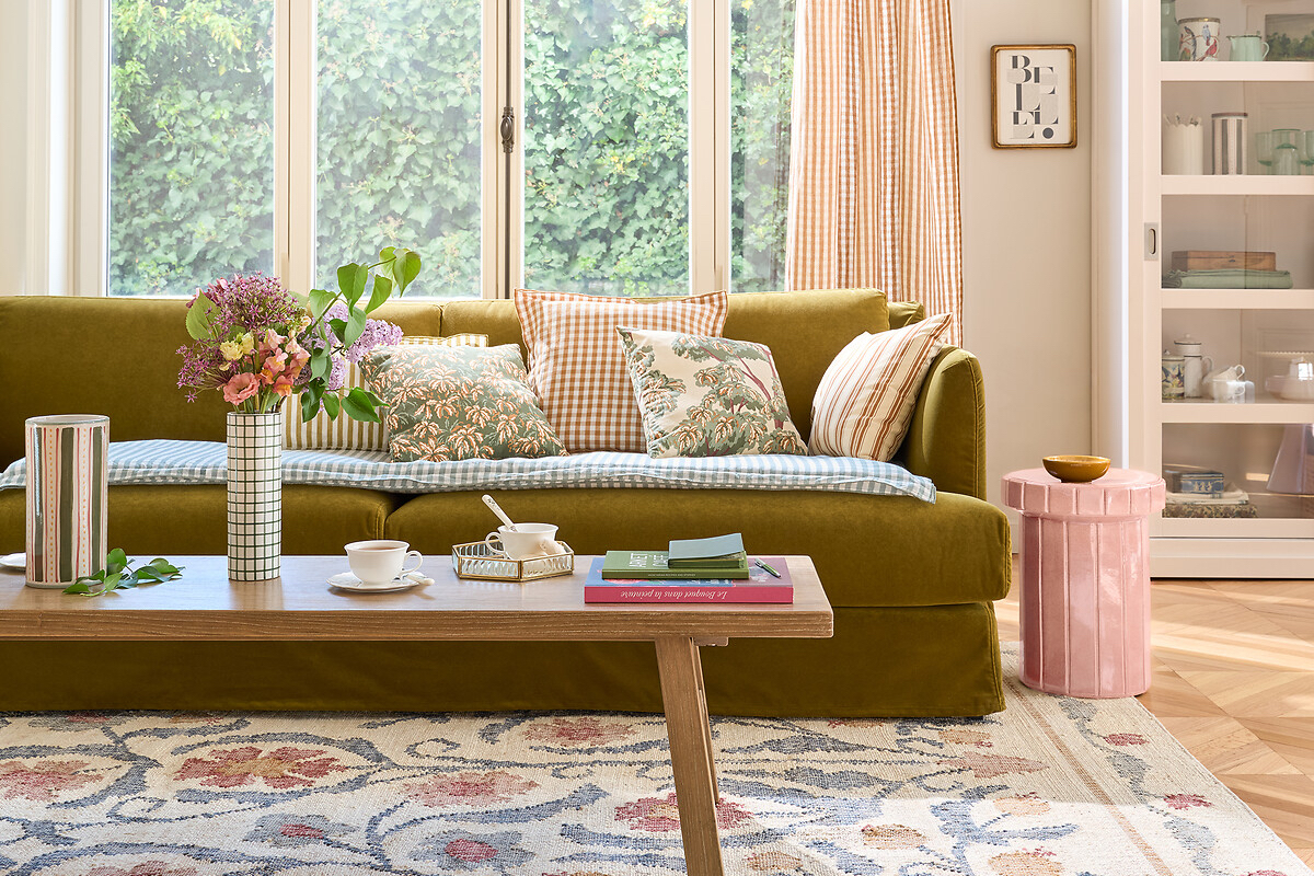 living room with green sofa and patterned folk-style rug with a wooden coffee table