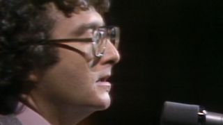 A side view of Randy Newman performing on SNL