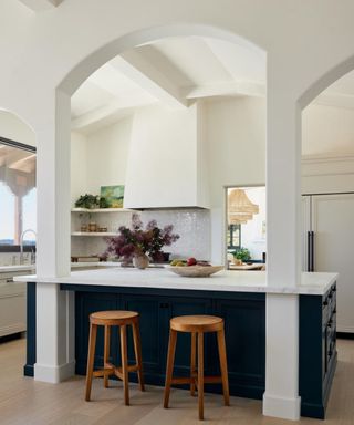 Warm white kitchen with dark blue island