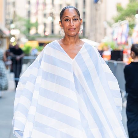 Tracee Ellis Ross wearing a flowy blue and white short. She has her hair in a slicked back bun. 
