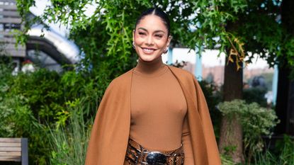 Vanessa Hudgens in a brown dress and shawl in a garden