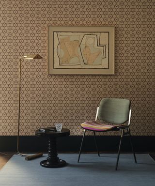 chair and side table against brown wallpapered wall