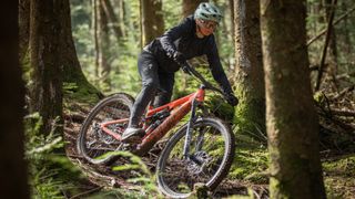A woman riding an electric mountain bike through the woods