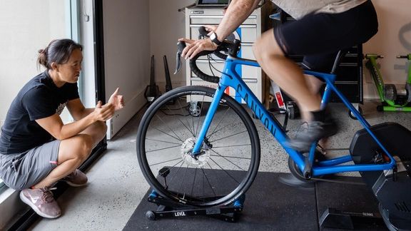 A bike fitter checking a customer&#039;s position