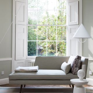 room with white wall window and grey sofa
