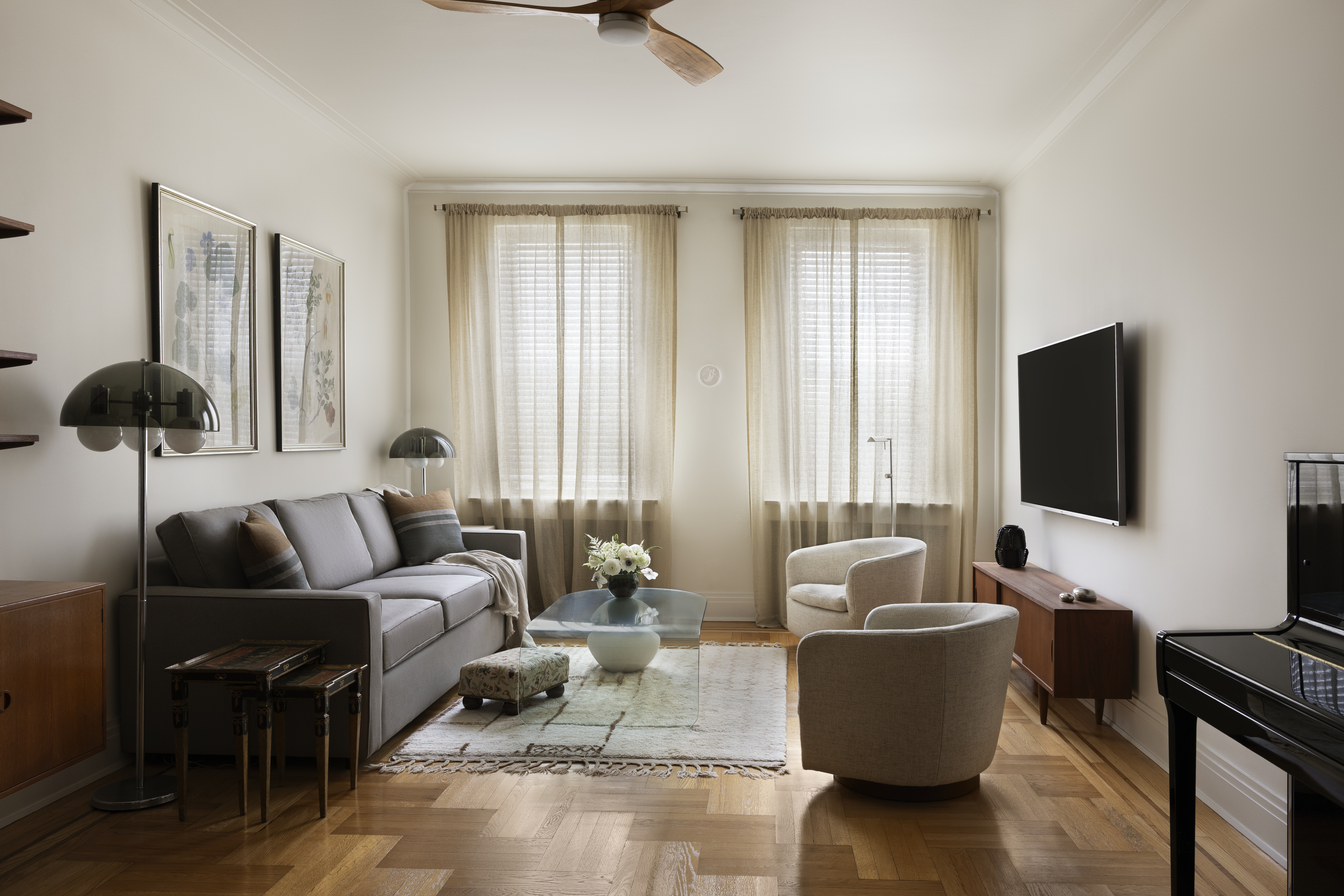 A beige-toned living room with wood floors and mid-century modern accents.