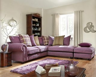 living room with purple couch and wooden table