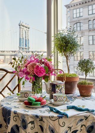 table setting with a blue patterned table cloth and a floral arrangement