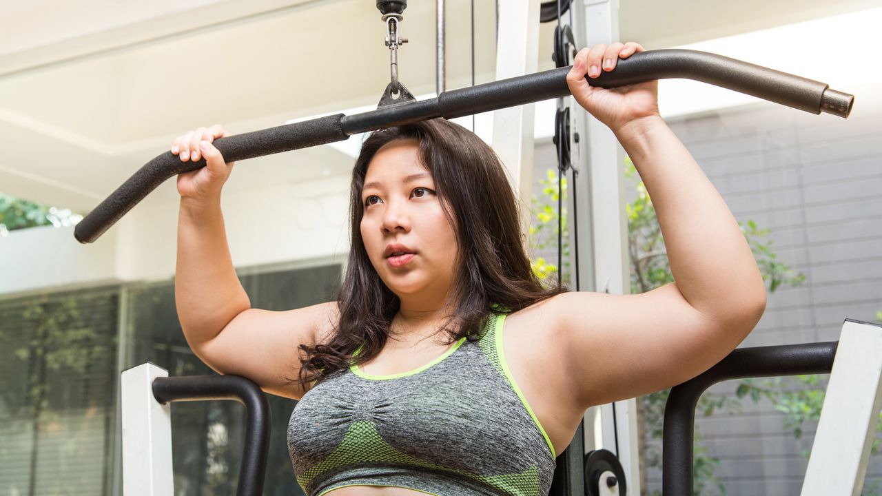 Woman doing lateral pulldowns in gym