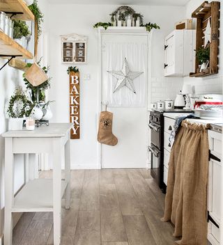 shabby chic kitchen with white units and wooden floor