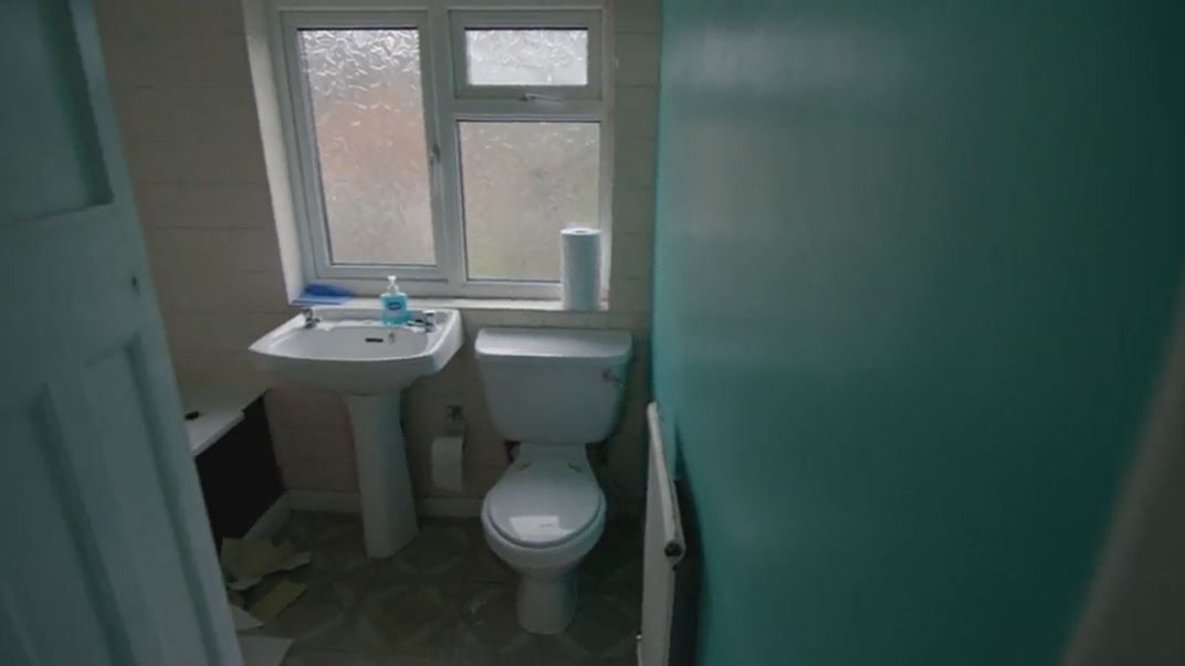 The bathroom before a renovation with aqua coloured walls
