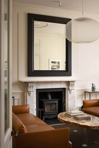 A leather sofa beside a fireplace in a home