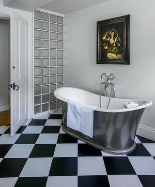 white bathroom with check tiles and photo frame