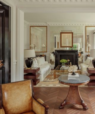 sitting room with wooden floorboards and white sofas