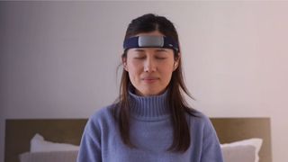 A woman wearing a purple jumper with eyes closed wearing Muse sleep headband